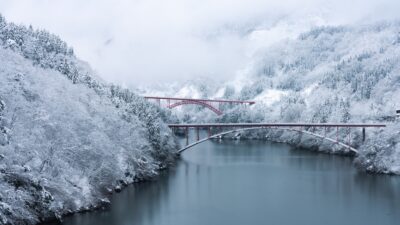 Red bridge over shokawa gorge river in toyama prefecture, japan