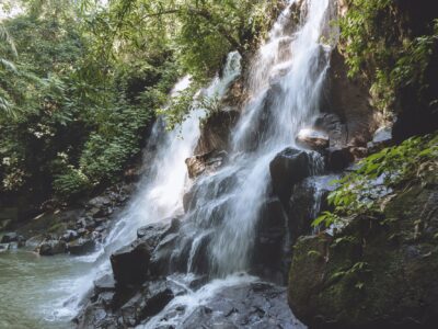 scenic view of beautiful Kanto Lampo Waterfall, green plants and rocks, Bali, Indonesia